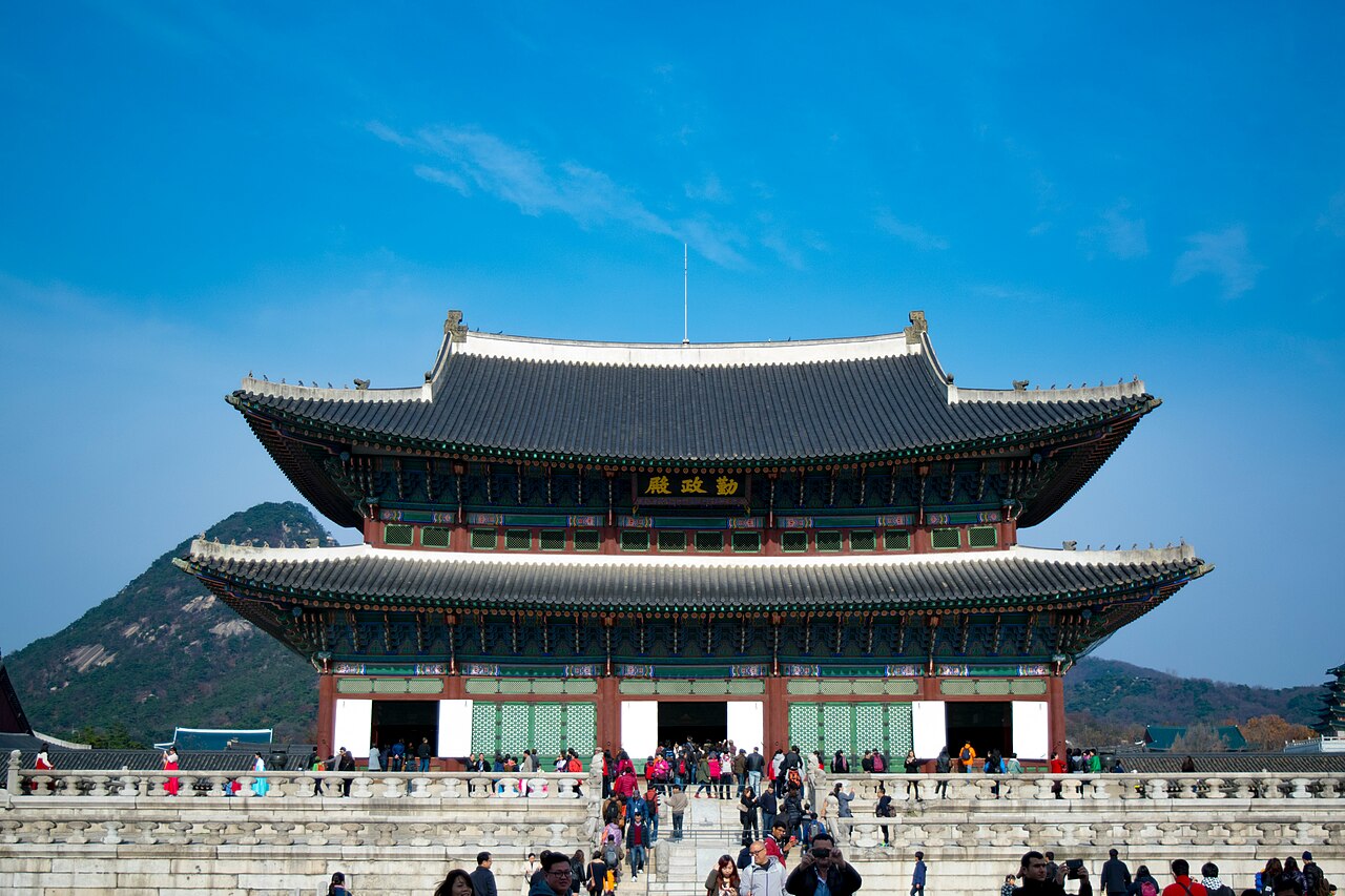 Geunjeongjeon Hall at Gyeongbokgung Palace in Seoul beneath a clear blue sky.